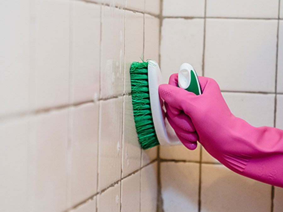 Person scrubbing dirty shower